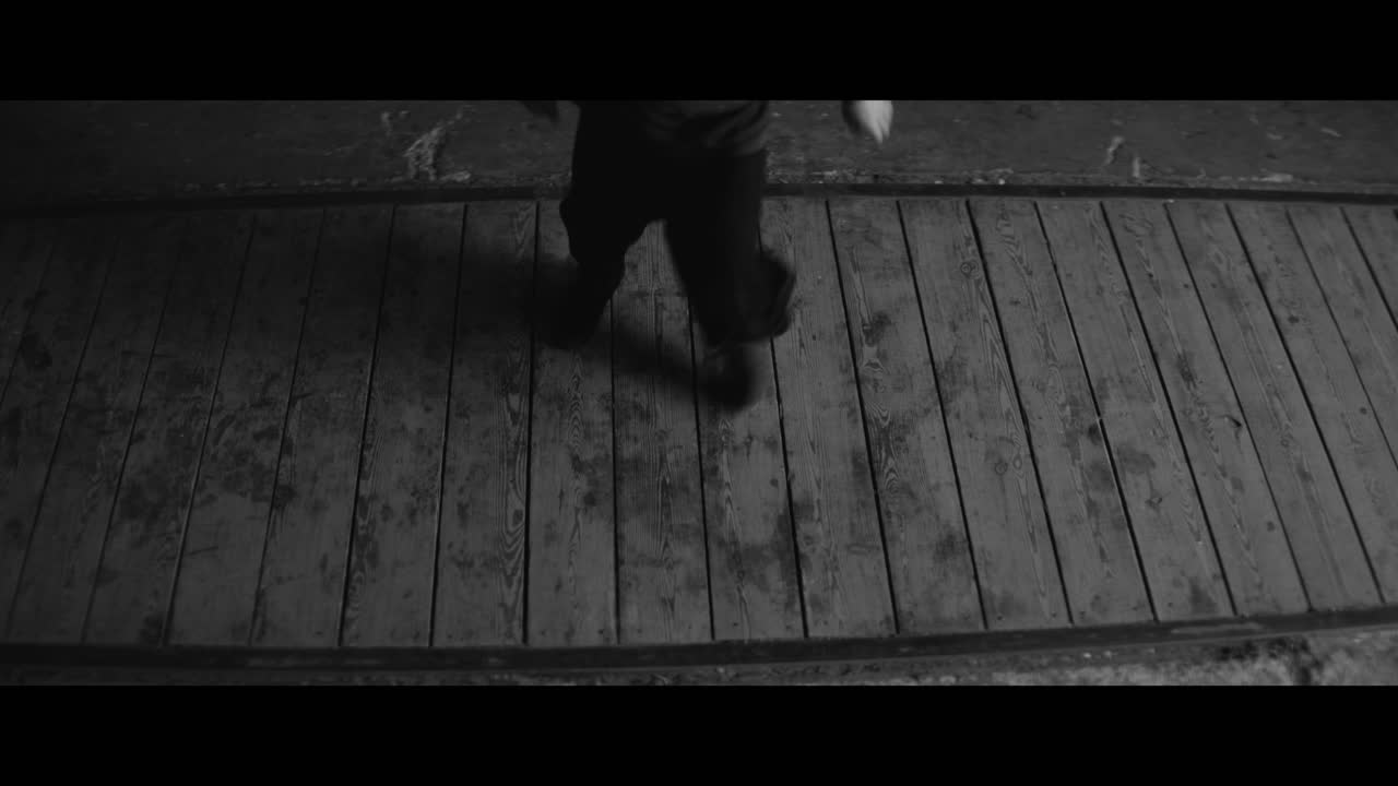 Person Performing a Dynamic Movement on a Wooden Floor