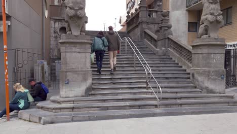 people walking in the city center of blankenberge. tourists climbing the stairs to the seawall and beach - belgium