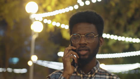 Black-Man-Talking-on-Phone-Outdoors-in-Evening