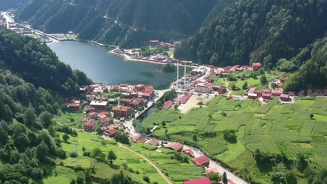 aerial drone revealing a beautiful lake and mosque in the center of a mountain village located in uzungol trabzon on a sunny summer day in turkey