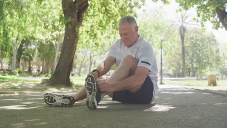 Hombre-Mayor-Atando-Los-Cordones-De-Sus-Zapatos-En-El-Parque