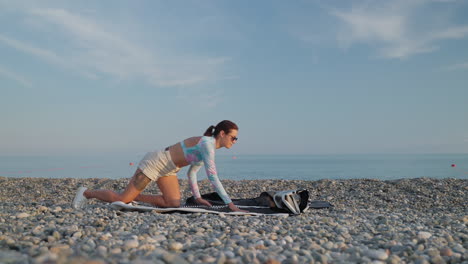 woman preparing an inflatable mat on a pebble beach