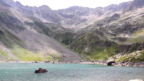 Blauer,-Ruhiger-See-Mit-Einem-Großen-Felsen-In-Der-Mitte