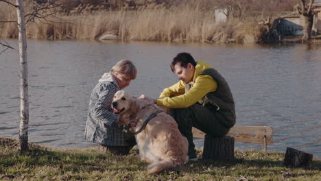 family enjoying time with their dog by the lake