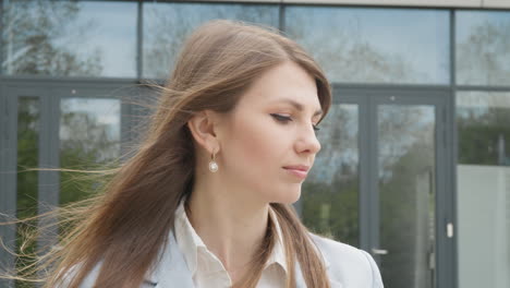 portrait woman smiling charmingly while standing in the middle of modern urban city landscape