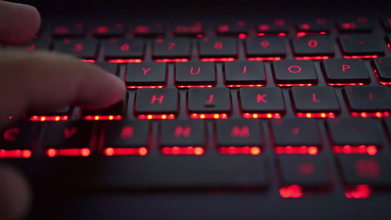 Close-up of hands typing on glowing laptop keyboard, modern technology, digital workflow, and productivity concept.