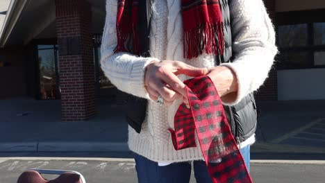 an elegant woman ties a christmas bow