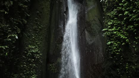 slow motion panning up shot in front of a gushing leke leke waterfall in bali, indonesia following a rain storm