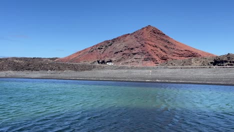 lago verde con montaña roja en el fondo en los volcanes de lanzarote
