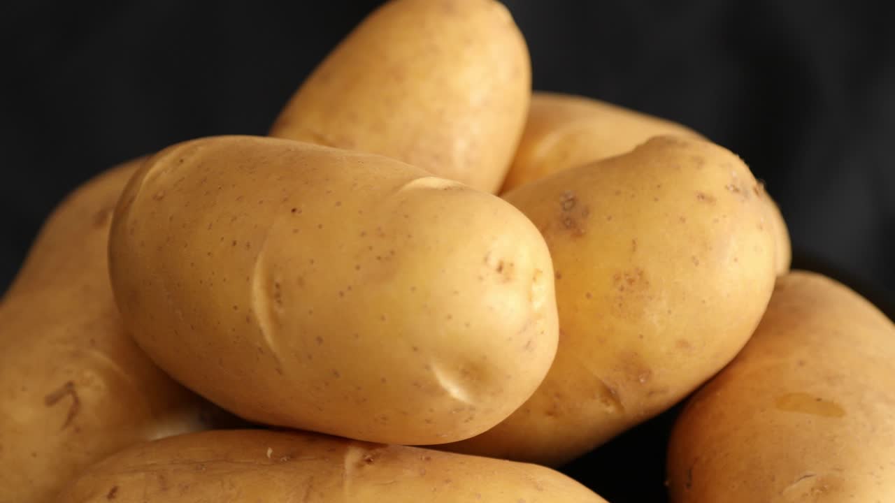 patatas crudas que giran y giran aisladas sobre un fondo negro 4