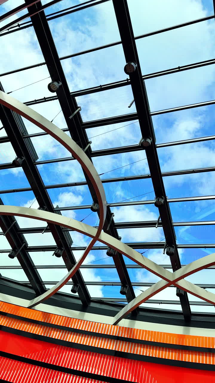 Modern glass ceiling in an office building. Modern glass roof with a view of the sky. Metal structure with transparent windows