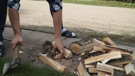 Young man is chopping wood for the for the fire place