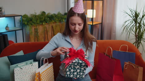 happy young woman hold birthday gift box with ribbon, celebrating party, opening present at home