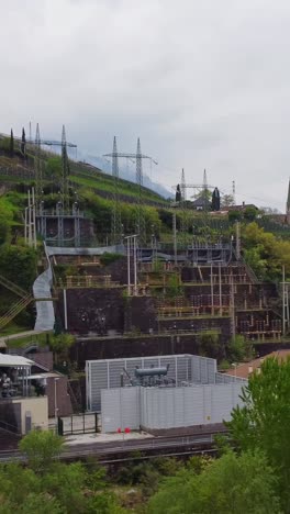 hydroelectric station on hillside, power lines, cloudy mood in bolzano, italy