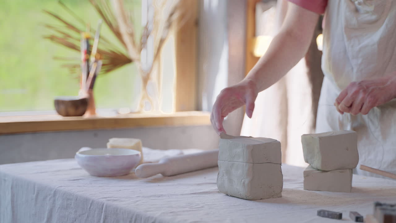 женщина, работающая с глиной в керамической студии