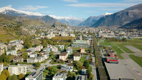 Línea-Ferroviaria-En-La-Ciudad-De-Sion,-Cerca-Del-Aeropuerto,-En-El-Soleado-Otoño.