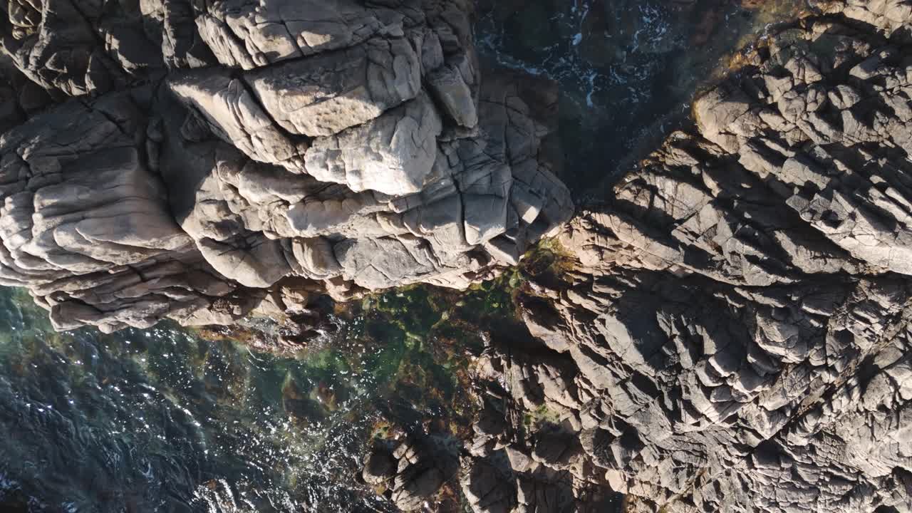 imágenes aéreas de drones de mar cristalino sobre rocas de granito con olas, piscinas de roca y ensenadas en un día soleado