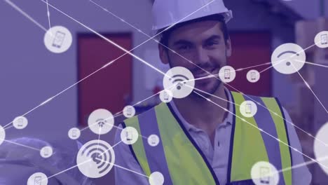 Animation-of-network-of-digital-icons-against-caucasian-male-worker-smiling-at-warehouse