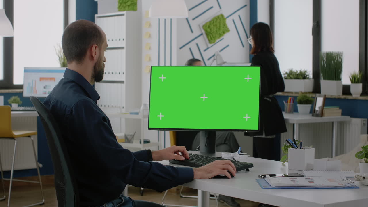 Man with office job working on computer with green screen