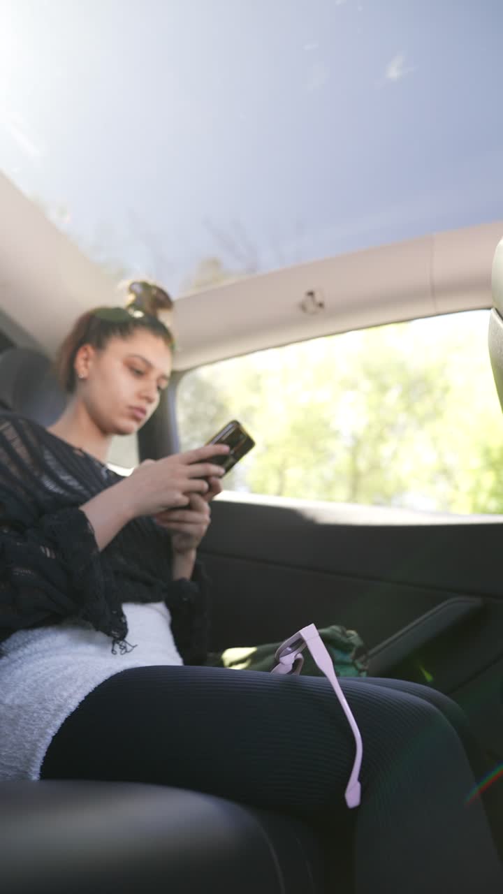 자동차에서 스마트폰을 사용하는 여성