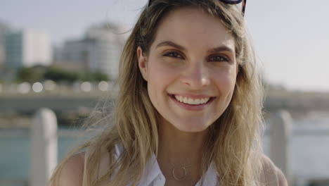 Primer-Plano-Retrato-De-Una-Hermosa-Joven-Riendo-Alegre-Y-Coqueta-Mirando-A-La-Cámara-Disfrutando-De-La-Soleada-Playa