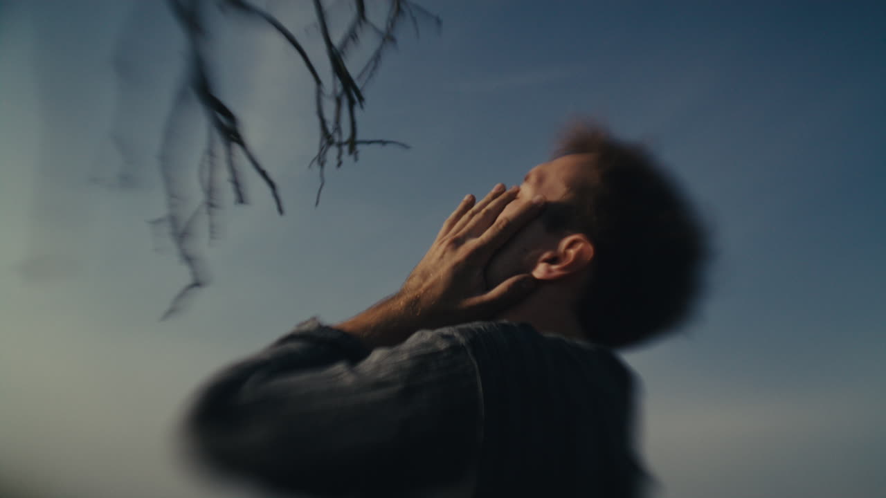 Blurred portrait of a man with hands covering his face