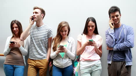 classmates standing in a row text messaging and calling