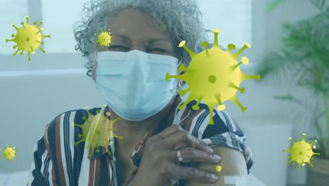 Animation-of-virus-cells-over-african-american-woman-with-face-mask