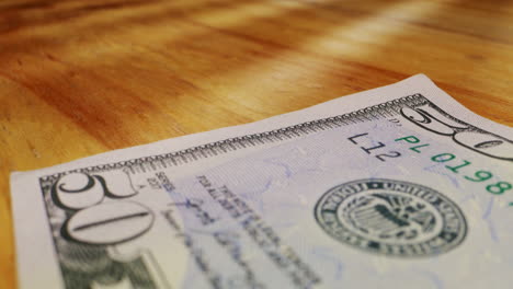 a closeup view of a fifty dollar bill on a polished wooden table, highlighting its intricate design