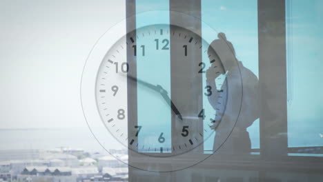 clock animation over businesswoman talking on phone by office window