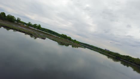 Eine-FPV-Drohnenansicht-Aus-Geringer-Höhe-über-Einem-Flachen-See-Mit-Reflektierender-Oberfläche