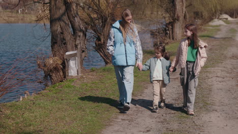 sisters walking along a path by a lake