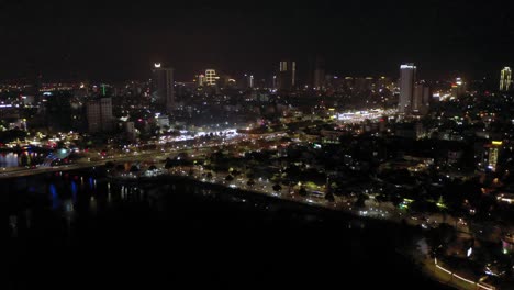 Night-time-aerial-of-city,-Han-River-and-skyline-in-Danang,-Vietnam