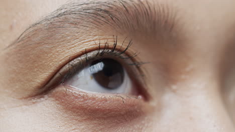 primer plano del ojo de una mujer asiática con cabello oscuro, cámara lenta