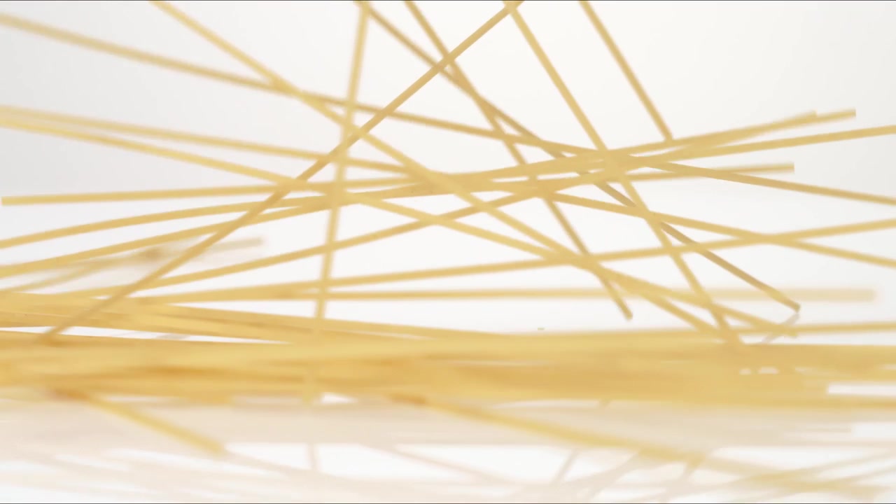 Spaghetti secchi non cotti, Capelli d'angelo, Linguine che rimbalzano su un tavolo bianco in slow motion, primo piano macro prima di posarsi
