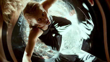 woman looking up amidst mirror reflections and light distortions