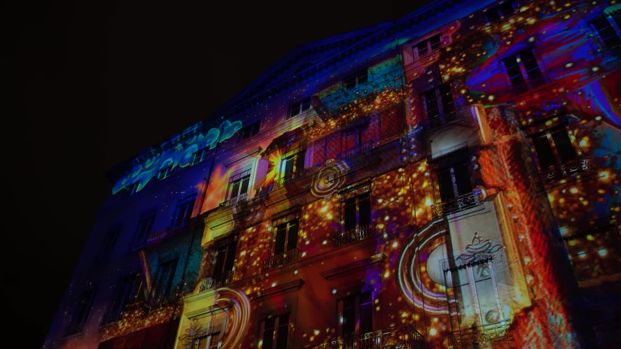 Colorful thematic digital art projected on building facades during Fête des Lumières festival in Lyon, France