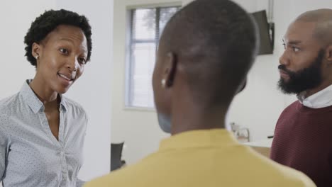 Happy-african-american-male-and-female-business-colleagues-discussing-in-office,-slow-motion