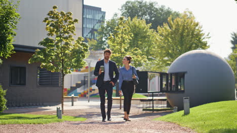 smiling managers strolling downtown in sunny morning. business couple talking