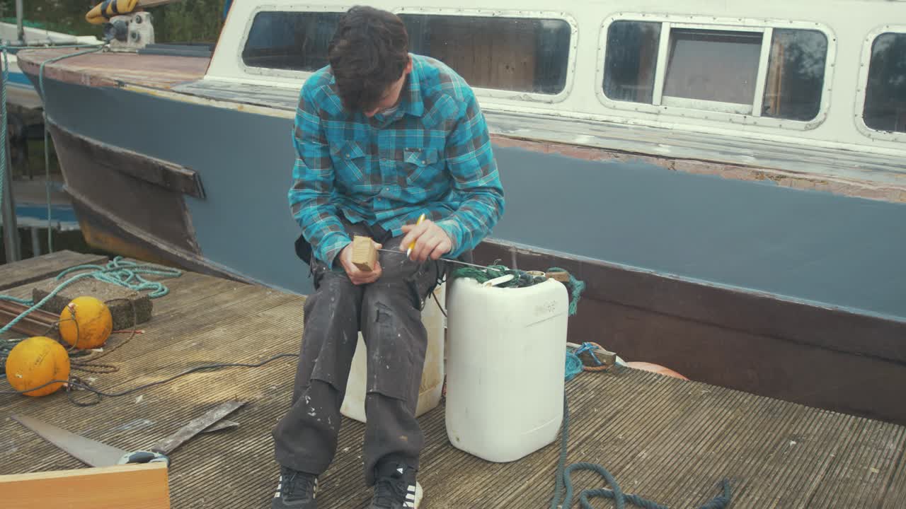 나무 배 앞 에 나무 를 표시 하는 젊은 목수