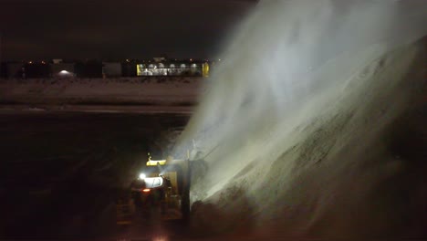 Rückfahrkamera-Verfolgt-Schneefräse,-Die-Einen-Schneehaufen-Aufwirbelt-Und-Eine-Frische-Schicht-Von-Den-Straßen-Räumt,-Luftaufnahme