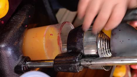 a person squeezing oranges to make fresh juice