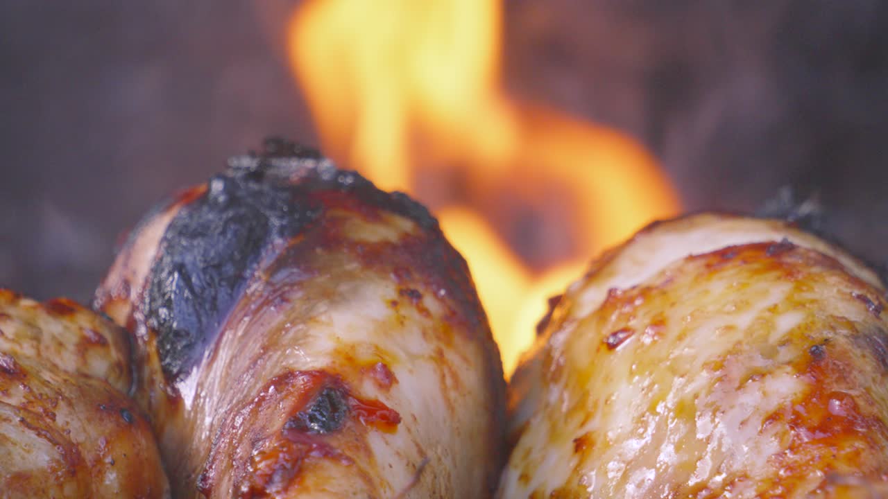 Details on Chicken Drumsticks Cooking on Barbecue with Hot Fire Flames Burning in Background. Juicy Meat Cooked Outside. Summer Concept Street Food Picnic Footage