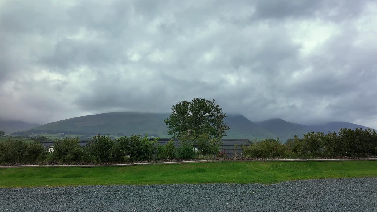 Timelapse of dramatic clouds racing over hills in UK's Lake District scenery.