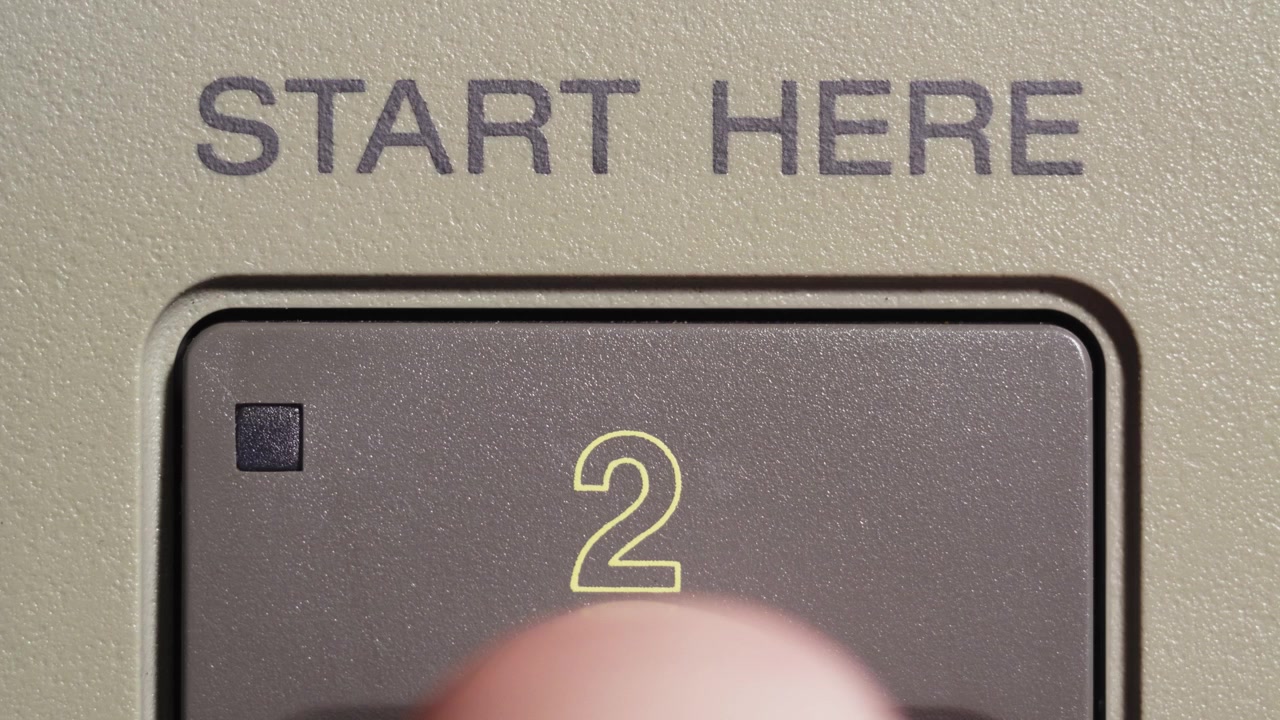 Finger presses start here button marked 2 on beige vintage editing remote controller
