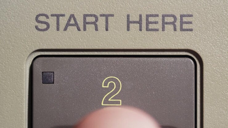 Dito preme il pulsante di avvio contrassegnato con il numero 2 su un telecomando di editing vintage beige