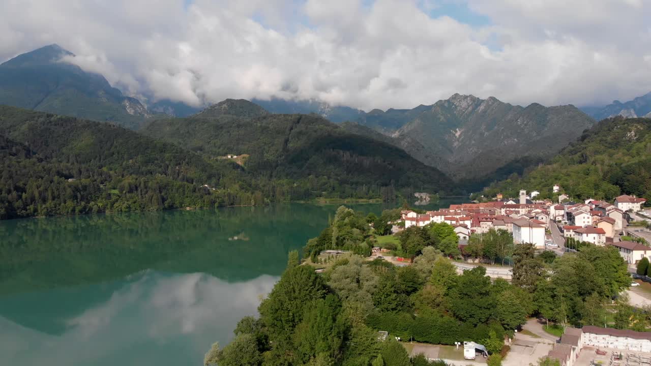 An Epic panoramic aerial drone flight over the village Barcis Italy in the dolomites with nice teal lake