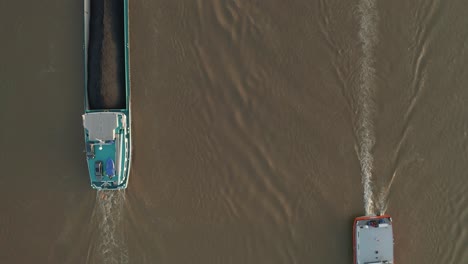 top shot of two ships boats meeting meet each other load and transport coal, petrol and gas with a radar device on the brown river rhine 24p