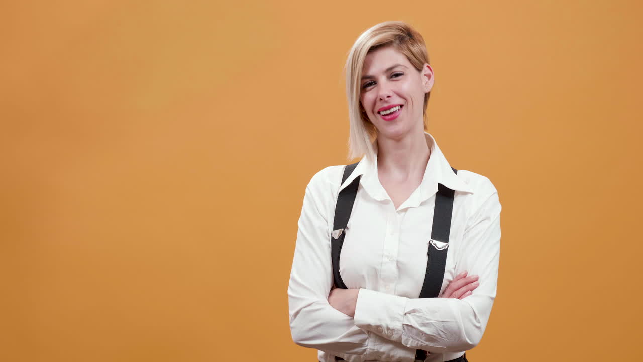 Woman in white shirt and suspenders with arms crossed