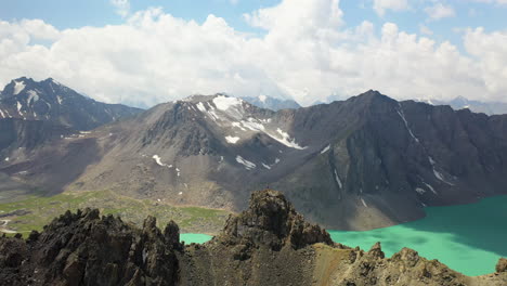 circling drone shot of a man on a mountain ridge overlooking the ala-kol lake in kyrgystan